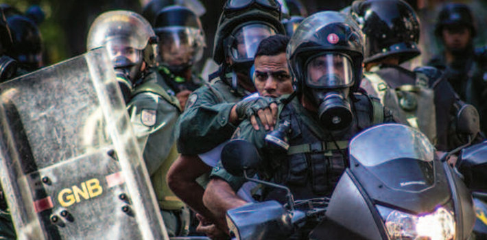 Venezuelan soldiers detain a student protestor