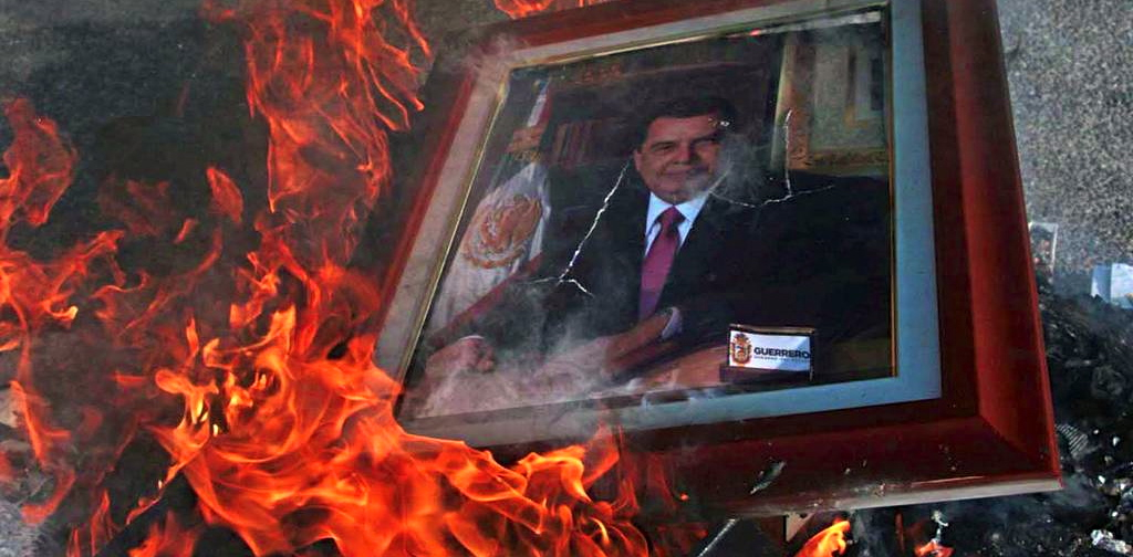 Protesters burn the portrait of Guerrero Governor Angel Aguirre in front of the government palace in Chilpancingo.